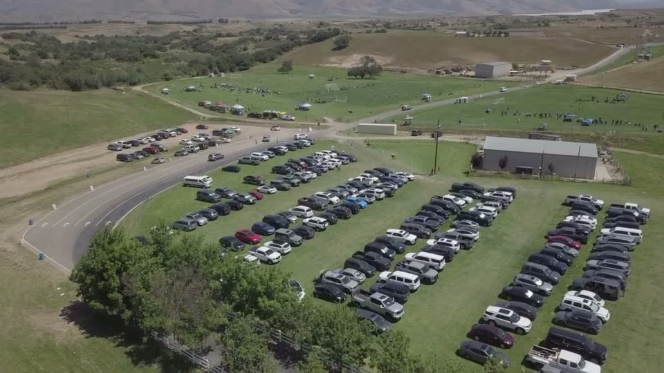 Aerial view of a tournament underway on the ranch's soccer fields, with hundreds of cars parked on the grass alongside.