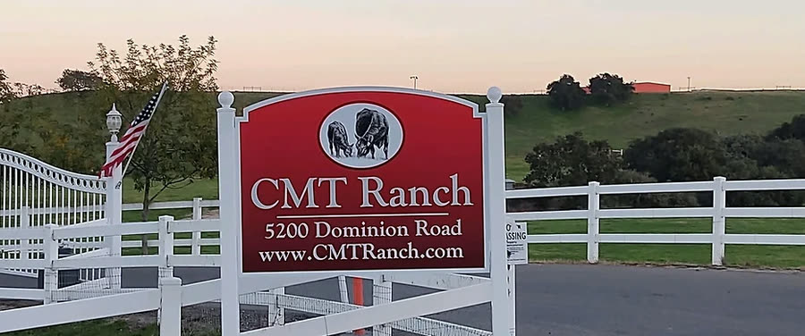 The C.M.T. Ranch entrance sign on Dominion Road at dusk, reading 5200 Dominion Road.